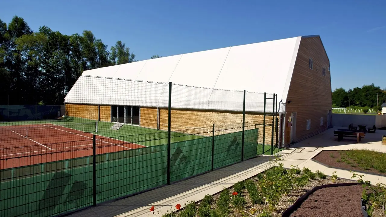 15x30m white aluminum frame tennis tent covering a standard court in France, designed for professional tournaments and training events.