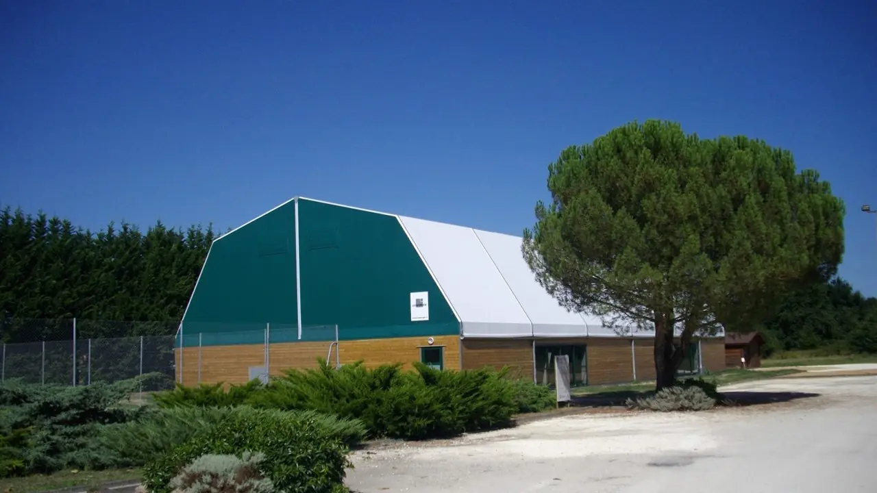 Branded 15x30m tennis event tent at night with sponsor logos, LED lighting, and VIP zone setup for professional French tournaments.