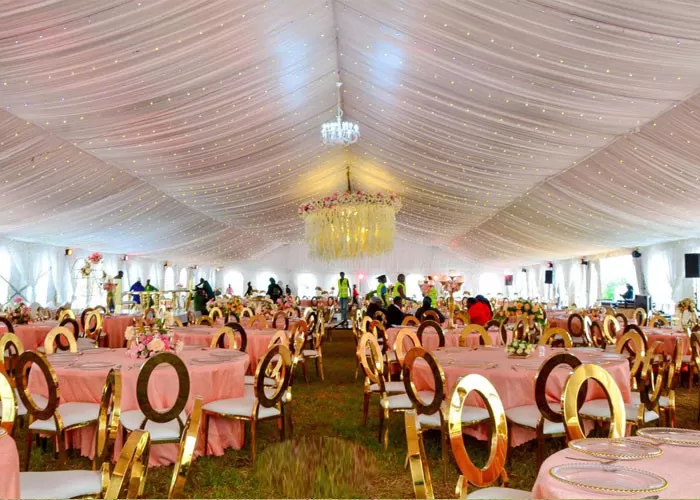 Interior of Italian clear wedding tent with banquet tables and chandeliers