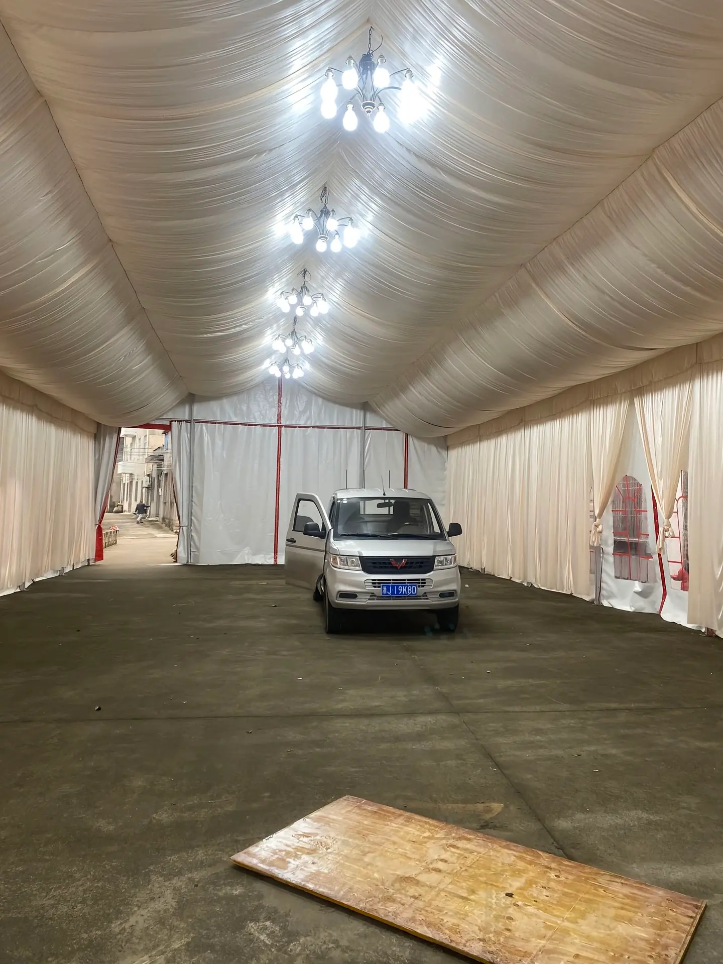 Interior view of 10x21m white wedding tent with elegant ceiling drapes and banquet table setup